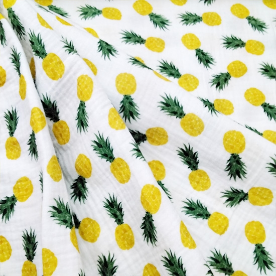 Weisser Musselinstoff mit urlaubsfrischen Ananasfrüchten bedruckt, ideal für luftige Sommerbekleidung für Gross und Klein.