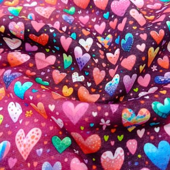 Kuschelweicher und warmer Sweatstoff in beere mit bunten Herzen gemustert