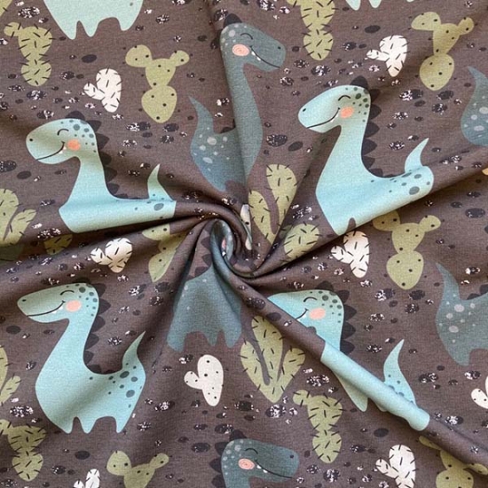 Preview: leicht angrauter French Terry in Olivgrün mit Dinos gemustert.