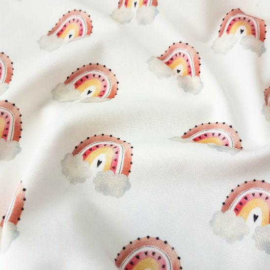 Weicher Baumwolljersey in offwhite mit süßen Regenbögen gemustert