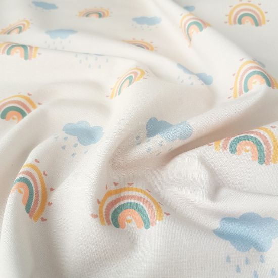 Weicher Jersey in ecru mit Regenbogenwolken gemustert