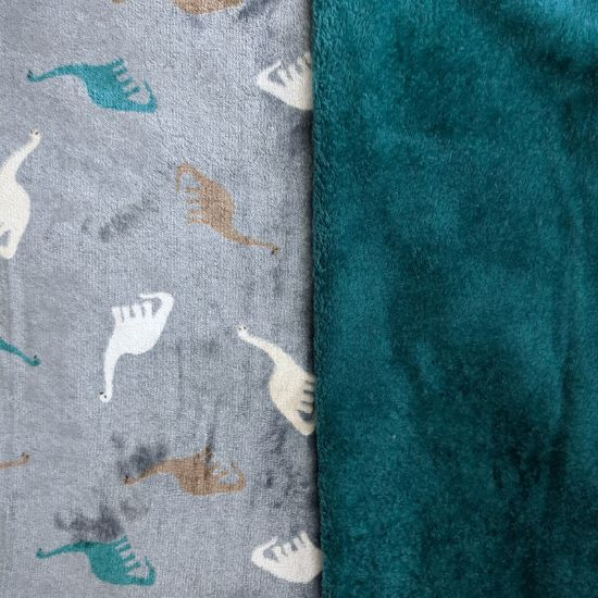 Kuscheliger Wellnessfleece in dusty blue mit Dinosaurier gemustert