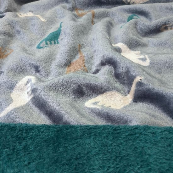 Kuscheliger Wellnessfleece in dusty blue mit Dinosaurier gemustert