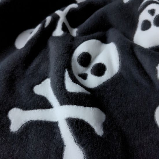 Kuscheliger Wellnessfleece in schwarz mit Totenköpfen gemustert