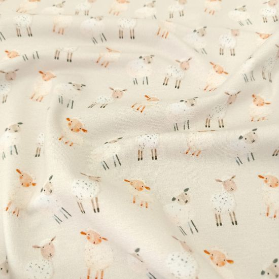 Kuschelweicher Jersey in hellem Sand mit Babyschafen gemustert