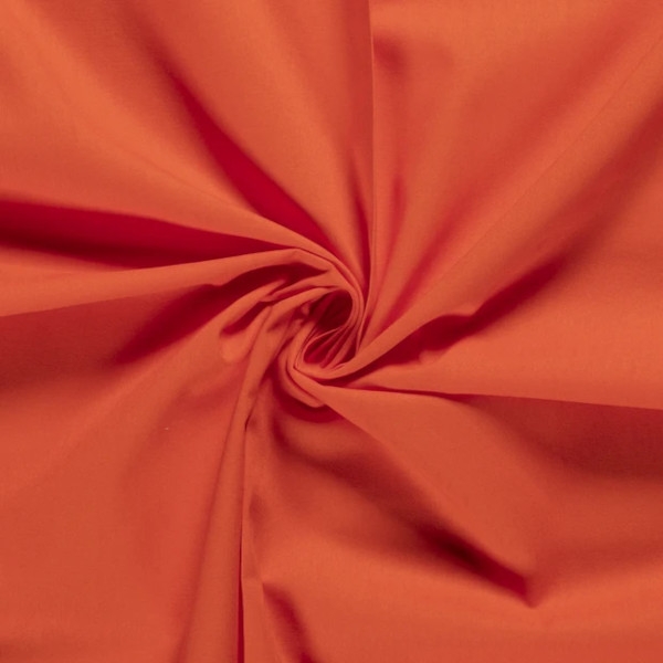 Baumwollstoff in orange mit verschiedenen Mustern.